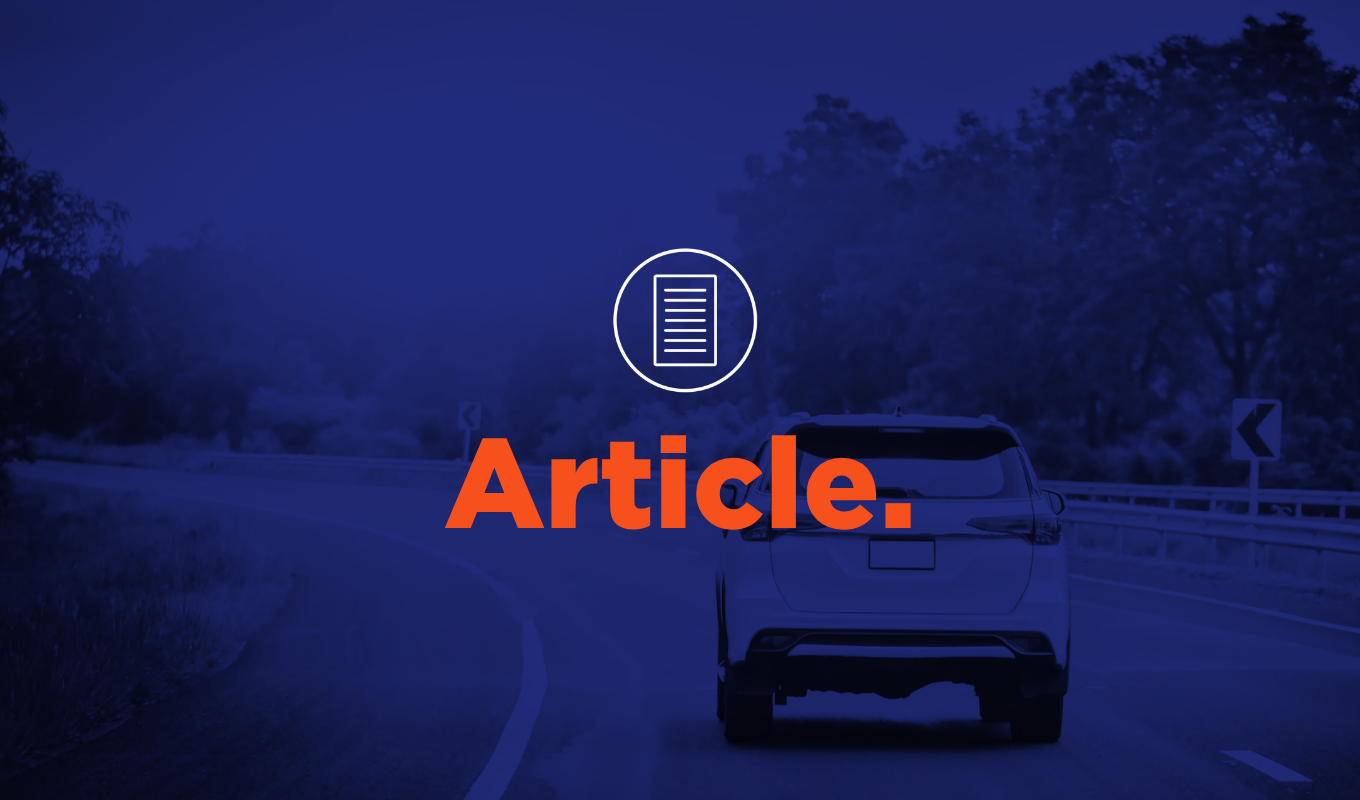 Article thumbnail featuring a car driving on a curved road surrounded by trees with bold orange text reading “Article.”